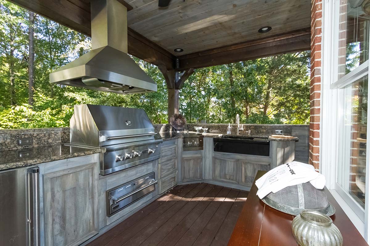 An outdoor kitchen with granite counter tops and stainless steel appliances.