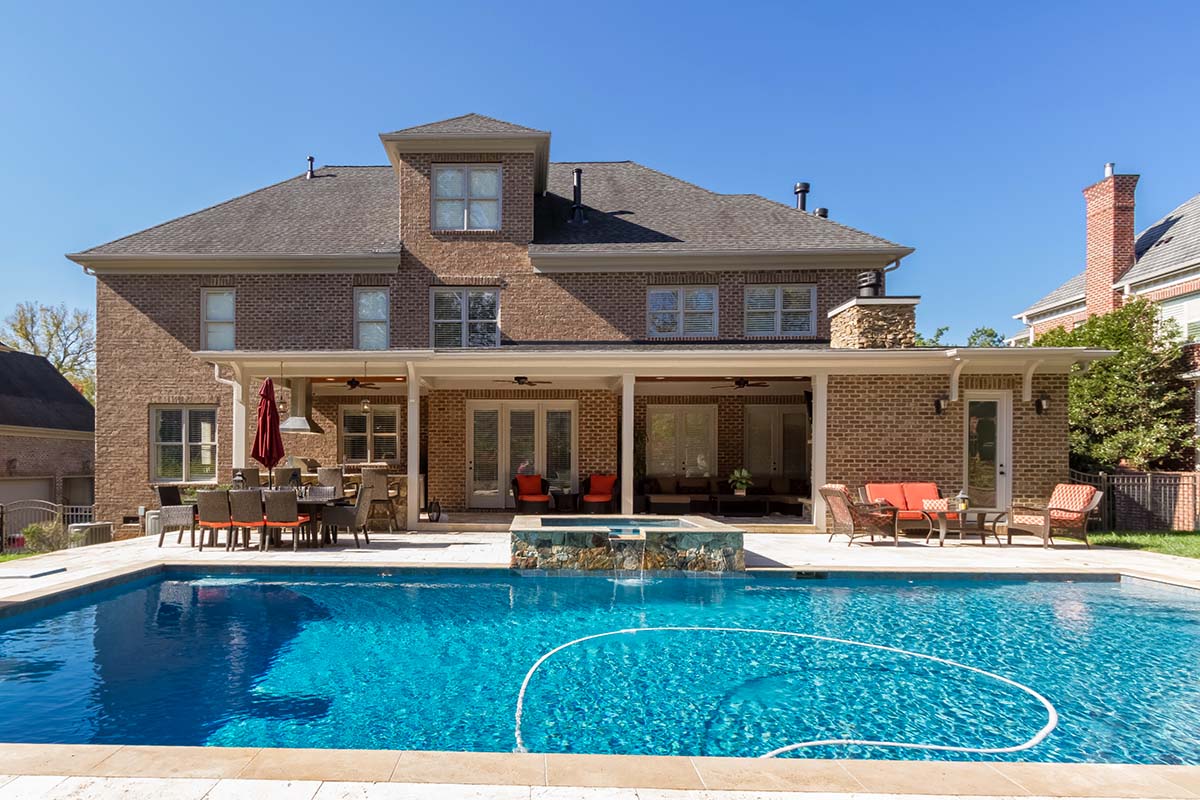 A home in Charlotte with a swimming pool, patio area and outdoor kitchen.