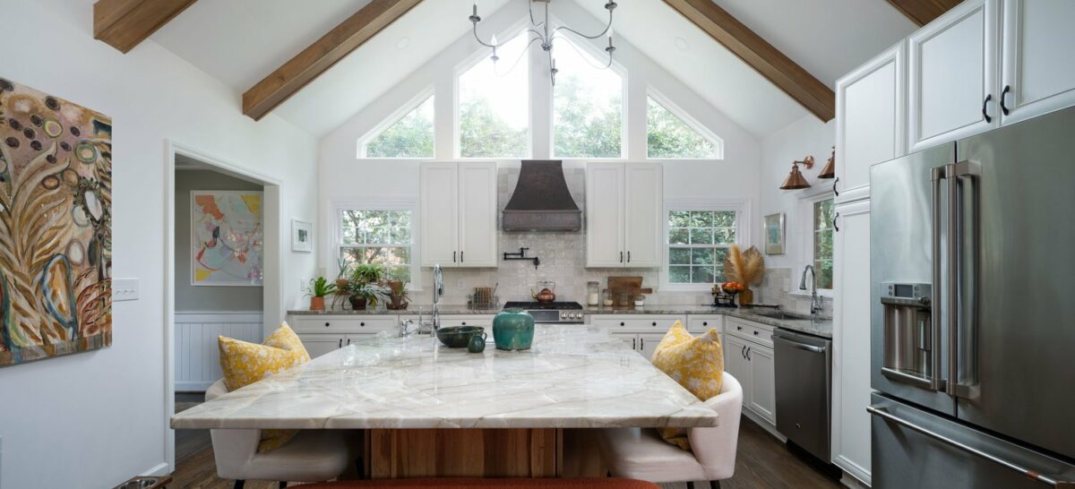 A kitchen with vaulted ceilings and white cabinets.