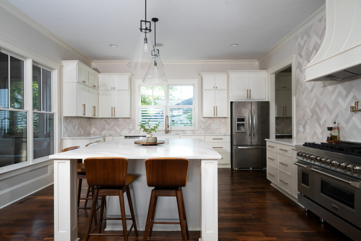 A white kitchen with large kitchen island with seating. 