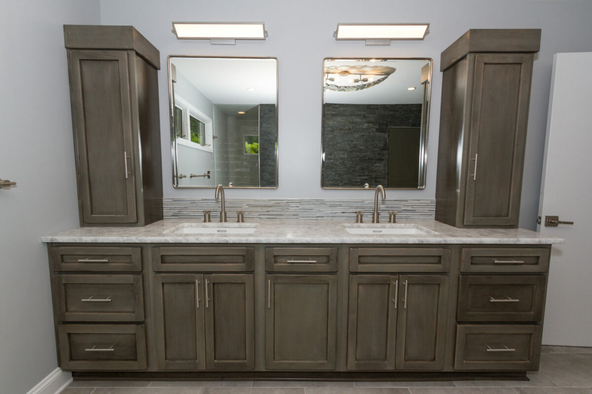A bathroom with double sinks, extra long vanity and mirrors.
